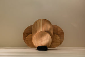 A set of wooden cutting boards of different sizes placed in a holder