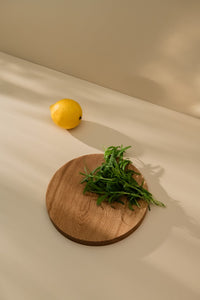Kitchen counter with lemon and some herbs placed on a small wooden cutting board